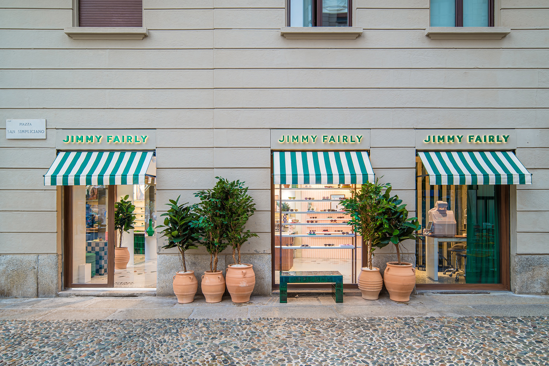 Façade de la boutique Jimmy Fairly Garibaldi avec stores verts rayés, grandes plantes et lunettes viisibles en vitrine.