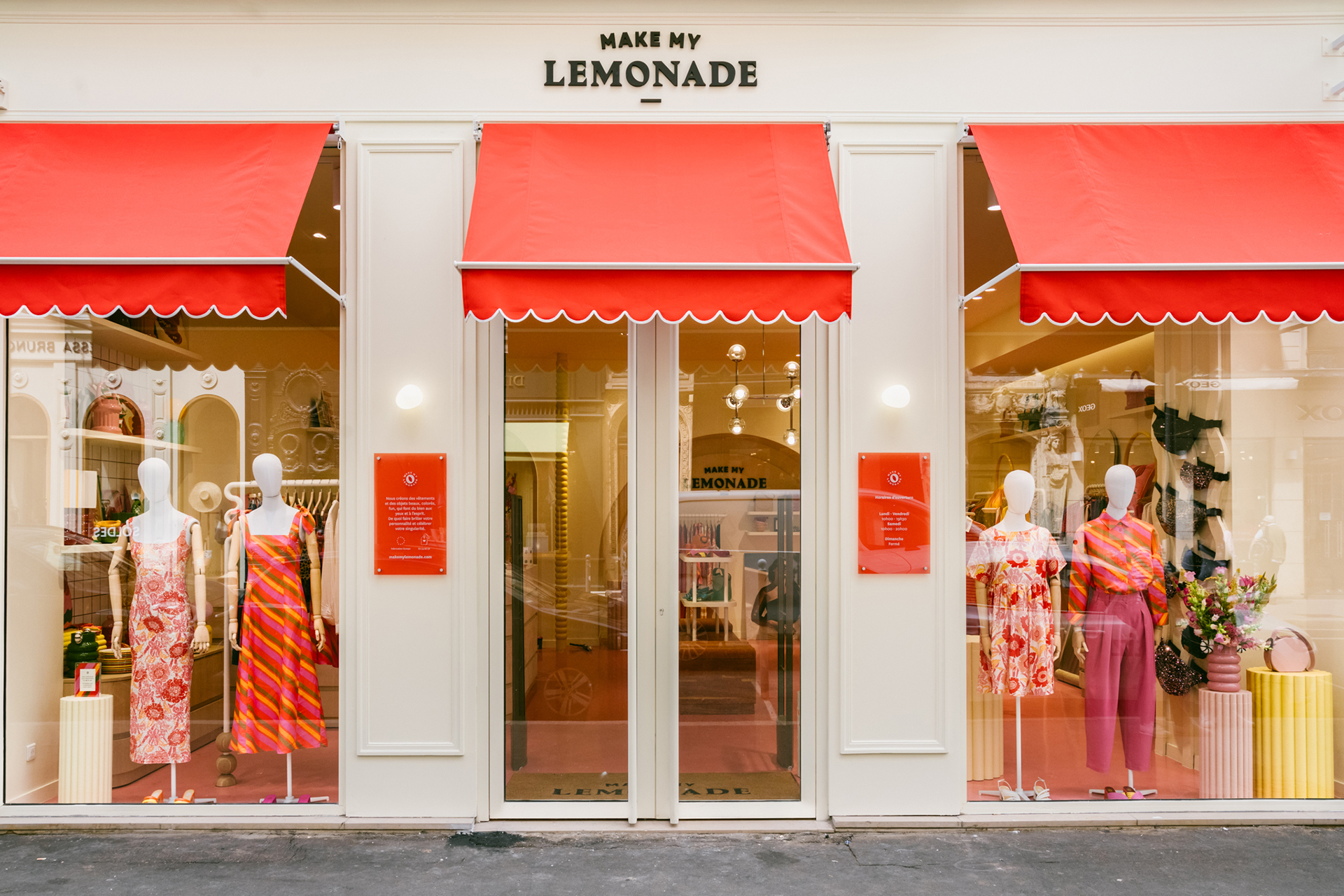 Façade crême avec des stores rouges au dessus des vitrines surplombées par l'enseign Make My Lemonade à Lyon.