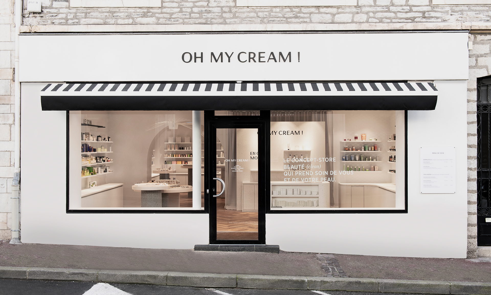 Façade avec auvent rayé noir et blanc, vitrines montrant les produits dans la boutique Oh My Cream ! de Biarritz