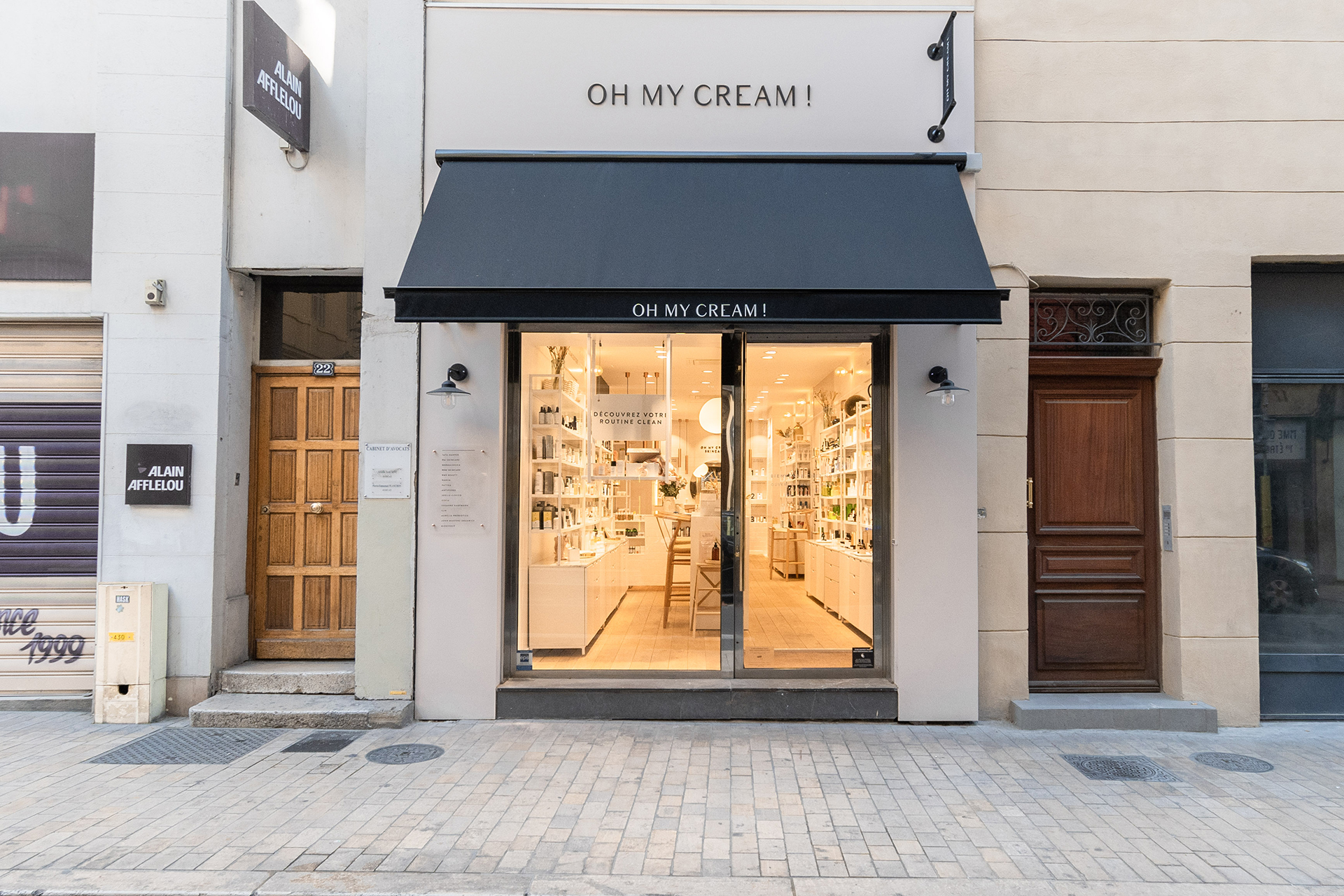 Façade avec une grande vitrine et marquise noire dans la boutique Oh My Cream !.