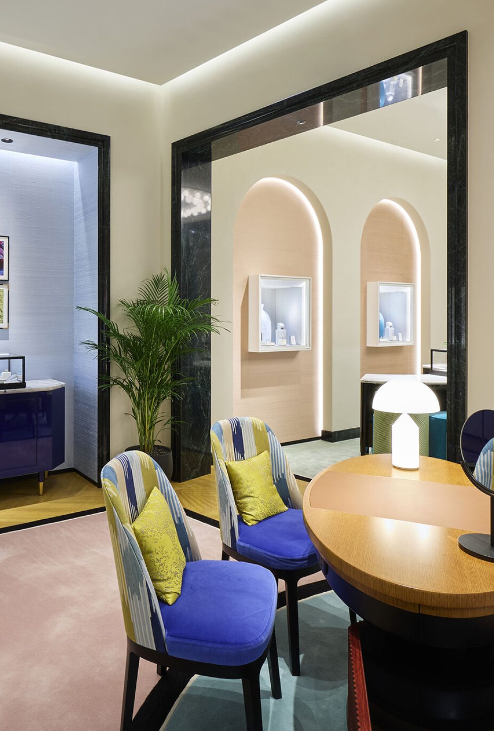 La table en bois et les fauteuils en dissus jeune et bleu de l'espace de vente de la boutique Boucheron de Busan.