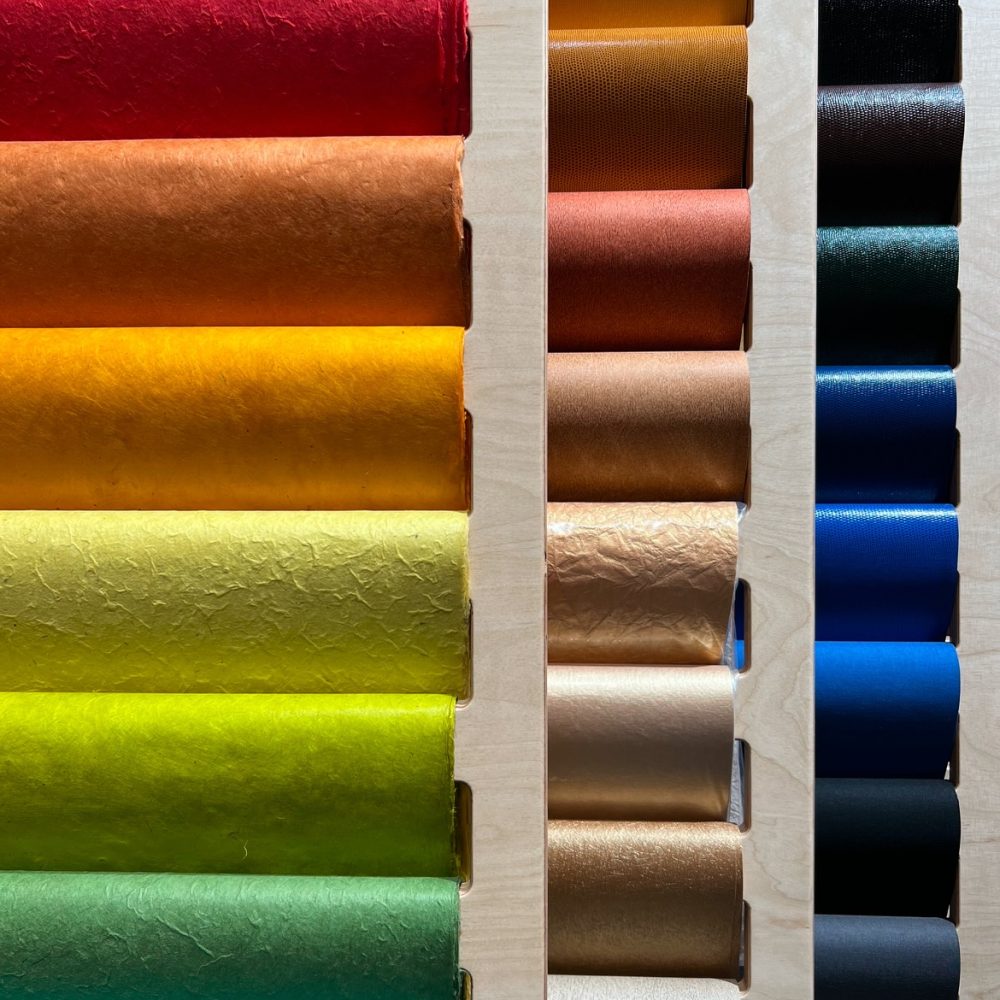 Rayonnage coloré avec des rouleaux disposés par teintes vives dans la boutique Rougier&Plé de Marseille.