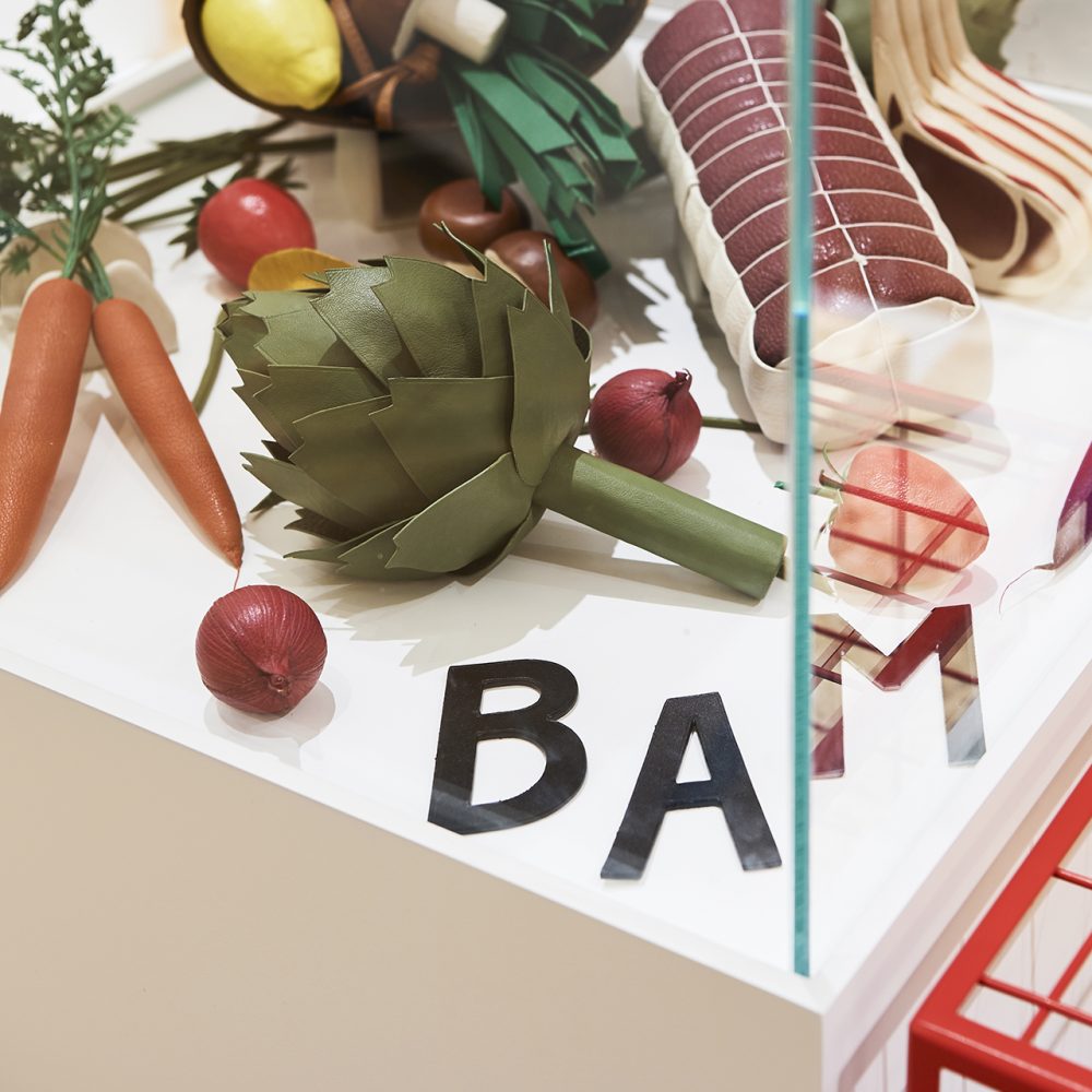 Zoom sur l'intérieur d'une vitrine décorée de faux aliments du Corner RSVP à Paris.