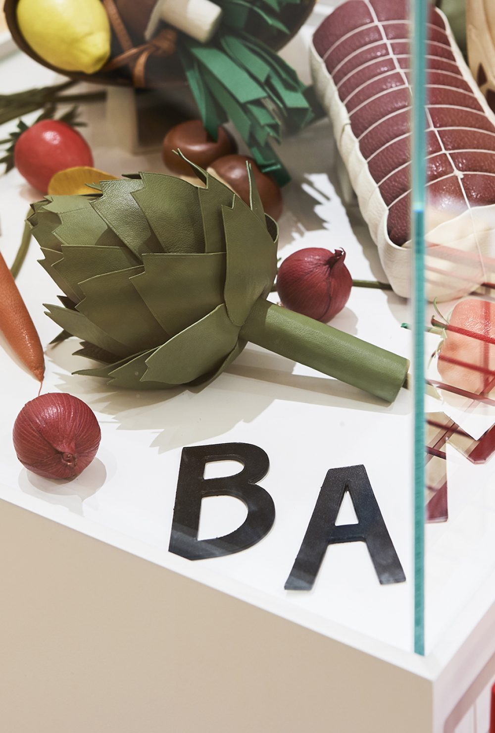 Zoom sur l'intérieur d'une vitrine décorée de faux aliments du Corner RSVP à Paris.