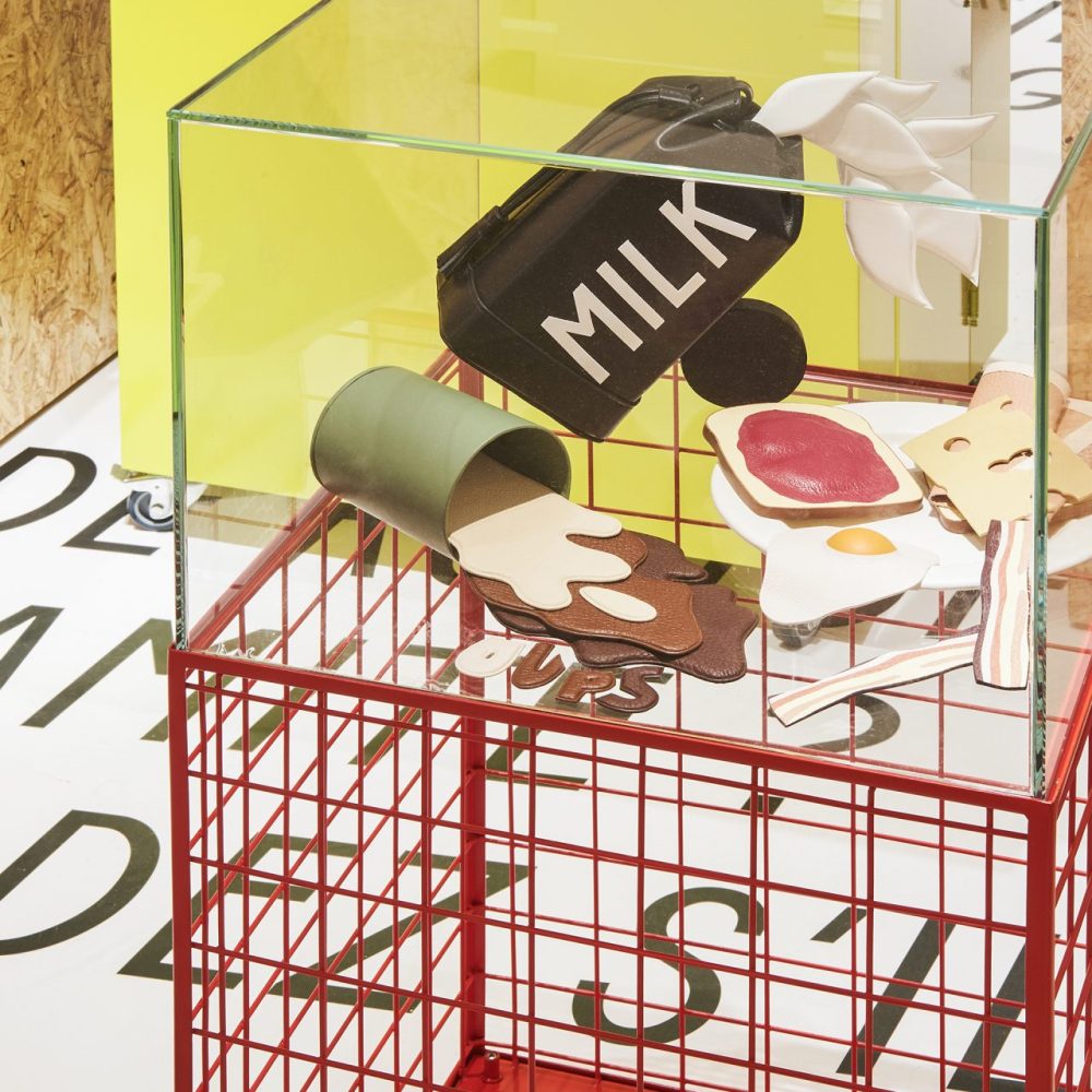 Zoom sur une vitrine reposant su un podium consitié de grille rouges dans le corner RSVP de Bon Marché à Paris.
